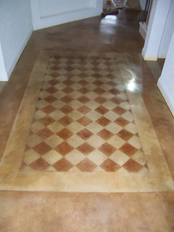 Scored and hand stained concrete floor rug design